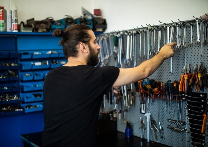 Automechaniker wählt Werkzeuge in der Werkstatt