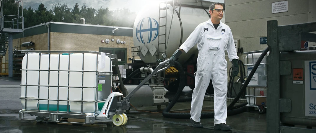 Ein Mann zieht einen beladenen Edelstahl-Hubwagen auf einem Außengelände